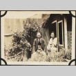 Two men sitting outside shed in garden (ddr-densho-423-518)