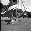 Boy on corkscrew slide in park (ddr-densho-426-961)