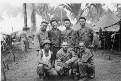 Seven men in fatigues by tents (ddr-densho-563-18)