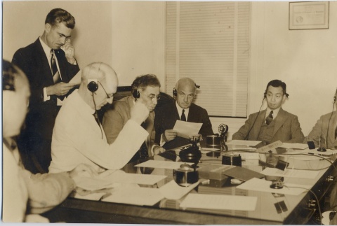 A group of men wearing headphones at a table (ddr-njpa-2-861)