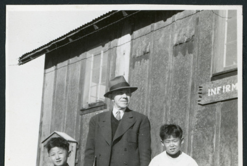Photograph of B.R. Chamberlain, Ned and Harry Morioka and two other children posing in front of the infirmary at Cow Creek Camp in Death Valley (ddr-csujad-47-138)