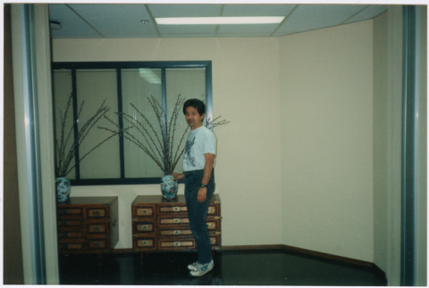 Man standing by small chest with vase (ddr-densho-426-1203)