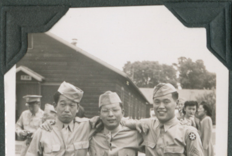 Three men standing outside camp buildings (ddr-ajah-2-529)