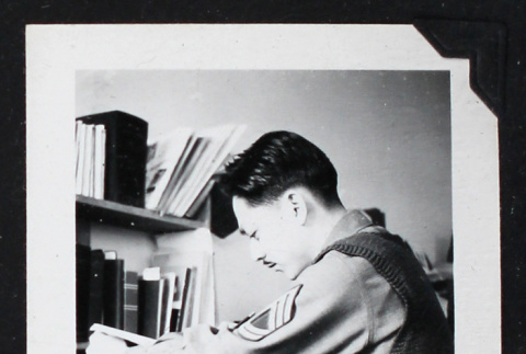 Man in military uniform sits at a desk (ddr-densho-404-84)