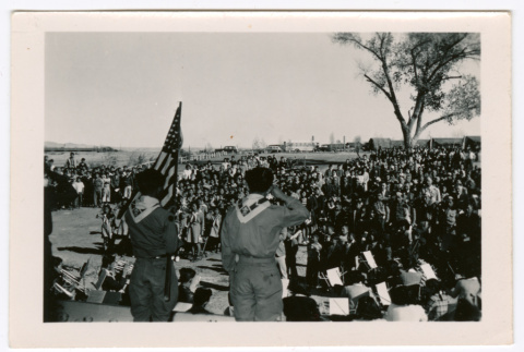 Boy scouts on stage with flag before large crowd (ddr-densho-475-383)