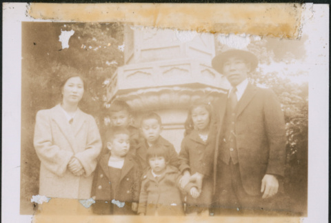 Man and woman with five children by stone pillar (ddr-densho-483-1009)