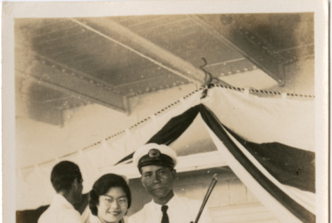 Tomoye (Nozawa) Takahashi on board ship, standing with man with violin (ddr-densho-426-1524)