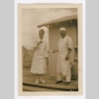 Henrietta Schoen and a man wearing an apron posing with doughnuts (ddr-densho-223-32)