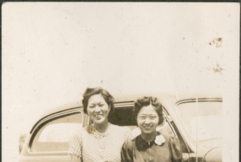 Two women standing in front of a car (ddr-densho-316-54)