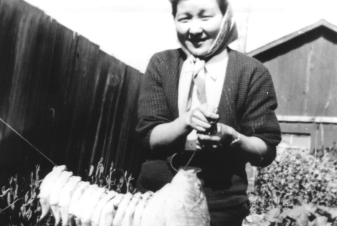 Japanese American woman hanging fish (ddr-densho-34-29)