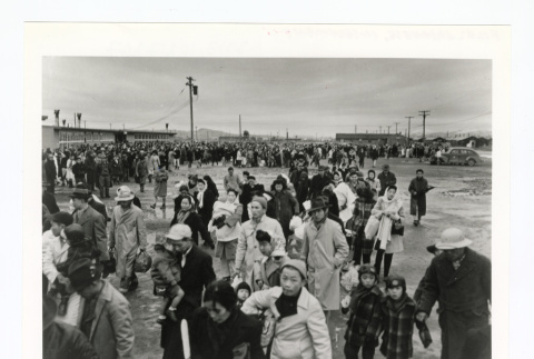 Large group people gathered in an open area near buildings (ddr-csujad-52-6)