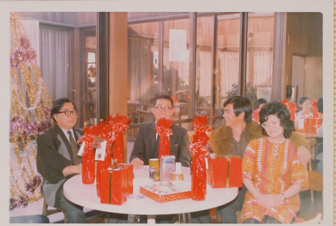 Four people seated at table with gifts (ddr-densho-426-1219)