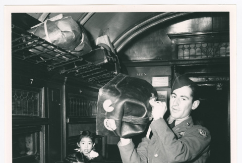 Serviceperson shouldering bag on train (ddr-densho-1007-209)
