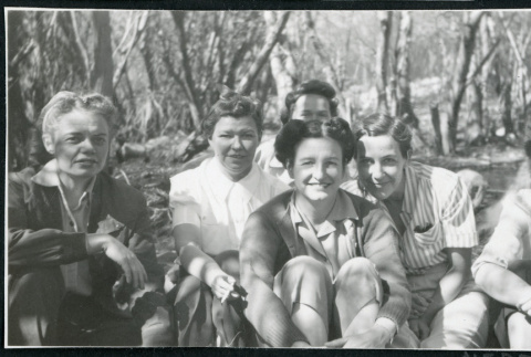 Photograph of a group of women sitting in front of a stand of trees near Manzanar (ddr-csujad-47-274)