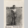 Shirtless man standing in field near tents (ddr-densho-466-251)