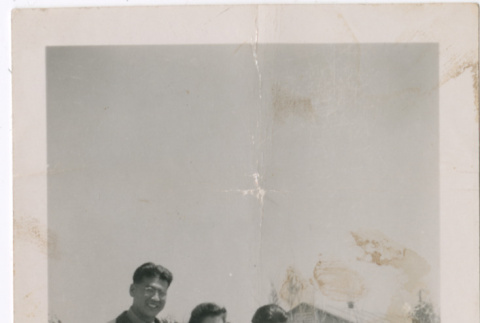 Woman and two men leaning on wall (ddr-densho-329-1325)