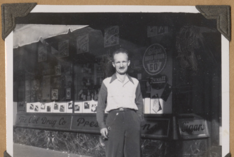 Man stands outside The Owl Drug Co. (ddr-densho-542-63)