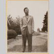 Man standing on gravel driveway (ddr-densho-522-18)