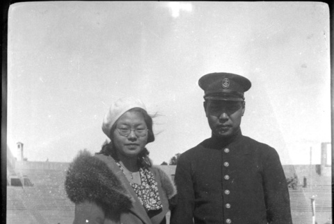 Tomoye (Nozawa) Takahashi standing with man in navel uniform (ddr-densho-426-2027)