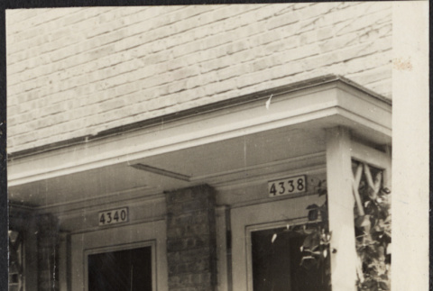 Couple standing outside duplex doorways (ddr-densho-523-172)