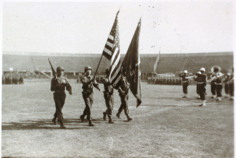 American soldiers marching with flags (ddr-densho-1007-595)
