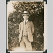 Man in a suit beside a tree (ddr-densho-483-560)