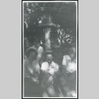 Photograph of four people, including L. Josephine Hawes, posing near a lantern at Manzanar (ddr-csujad-47-243)