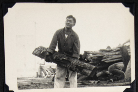 Man holding a log (ddr-densho-542-758)