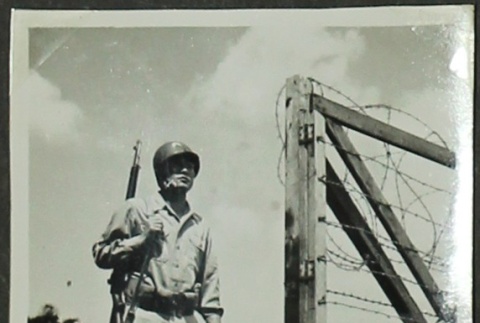 Soldier by barbed wire fence (ddr-densho-201-359)