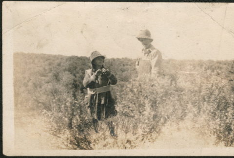 Two people standing in field (ddr-densho-293-203)