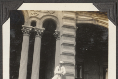 Navy sailor standing on the steps of a building (ddr-densho-432-62)