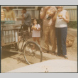 Two people and girl at sidewalk bicycle vendor (ddr-densho-523-508)