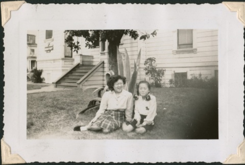 Two girls sitting under tree near dental building (ddr-densho-321-144)