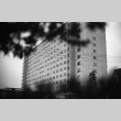 Looking through foliage at Seattle University dormitory (ddr-densho-354-2067)