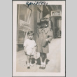 Boy and girl standing on sidewalk outside laundry (ddr-densho-483-683)