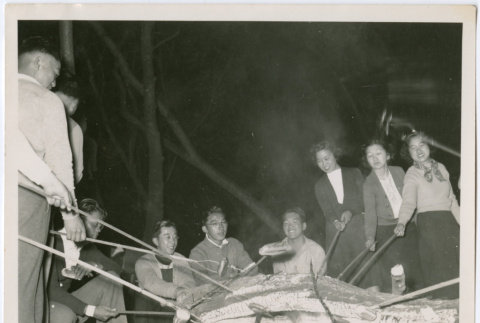 Roasting sausages on a campfire (ddr-densho-329-836)