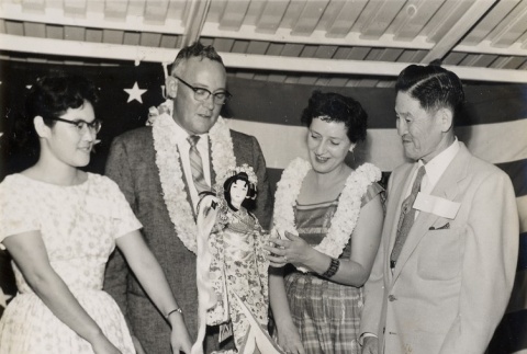 Two couples admiring a Japanese doll (ddr-njpa-2-422)