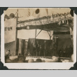 Man speaking on stage, with row of men behind him (ddr-densho-483-526)