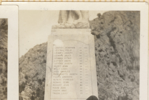 Man laying on base of monument smoking a pipe (ddr-densho-466-356)