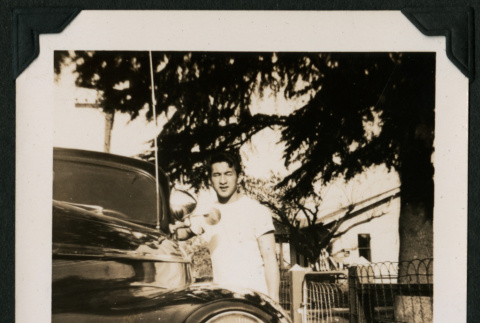 Walter Matsuoka stands next to an automobile (ddr-densho-390-88)