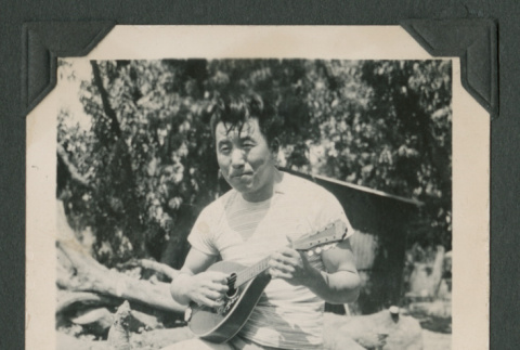 Man holding instrument (ddr-densho-471-181)