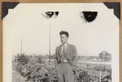 Man standing beside a garden (ddr-densho-542-144)