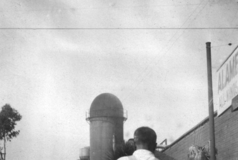 Man in overalls walking away from camera (ddr-ajah-6-423)