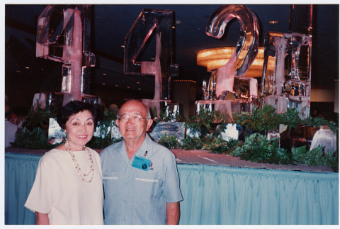 Bill and Tomi Iino in front of ice carving at banquet (ddr-densho-368-321)
