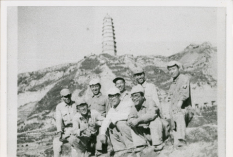 Eight servicepeople in front of hills and tower (ddr-densho-1007-188)