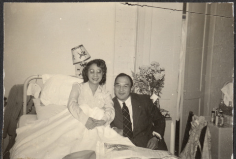 Agnes Sakura in hospital bed, with Chester Sakura seated next to her (ddr-densho-523-199)