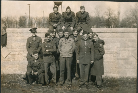 Group of men in uniform standing and sitting on wall (ddr-densho-434-500)