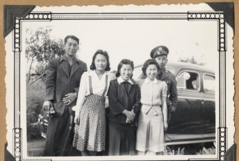 Group poses by a car (ddr-densho-542-49)