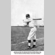 Man in baseball uniform with bat and ships in the background (ddr-ajah-5-58)