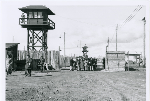 Guard tower and group at camp gate (ddr-densho-122-697)